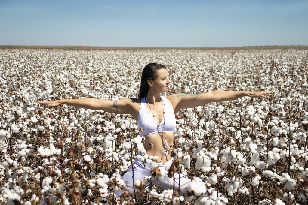 Praticante de yoga em campo de algodão