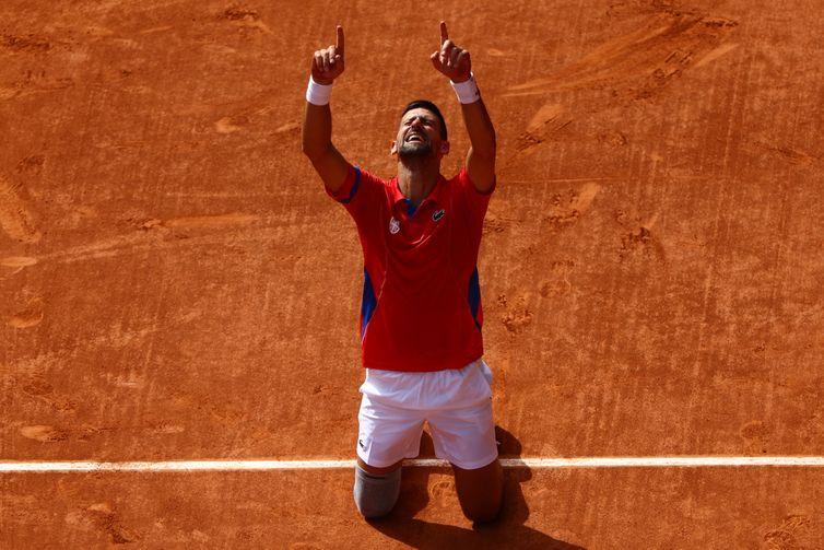 Paris 2024 Olympics - Tennis - Men's Singles Gold Medal Match - Roland-Garros Stadium, Paris, France - August 04, 2024. Novak Djokovic of Serbia celebrates after winning gold against Carlos Alcaraz of Spain. Reuters/Edgar Su/Proibida reprodução