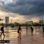 Brasília sob céu carregado, com chuva se aproximando entre prédios e árvores.
